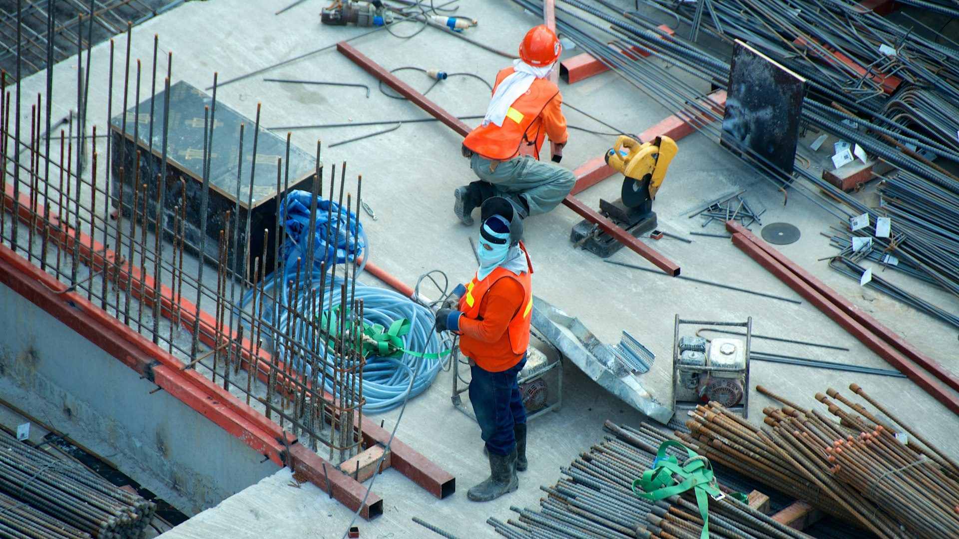 Construction workers handling rebar and heavy materials on site